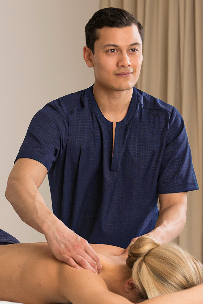 man wearing navy spa tunic massage